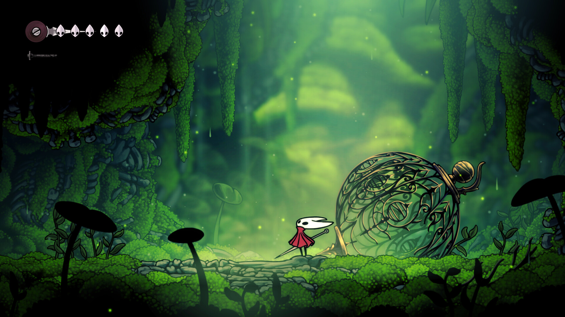 Hornet stands on a mossy ledge in a green overgrown cavern, facing a large ornate sphere wrapped in gold filigree and vines